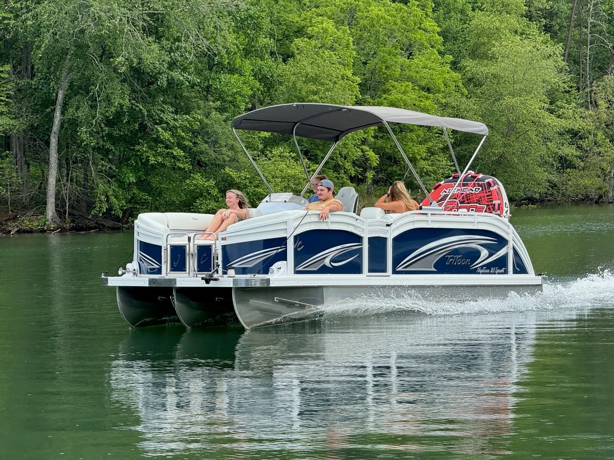 Group cruising on a tritoon pontoon boat on the lake